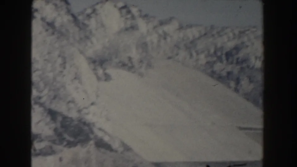 1959 Gibraltar 8mm view of a steep pale slope beside broken rock faces, with muted contrast and visible film texture.
