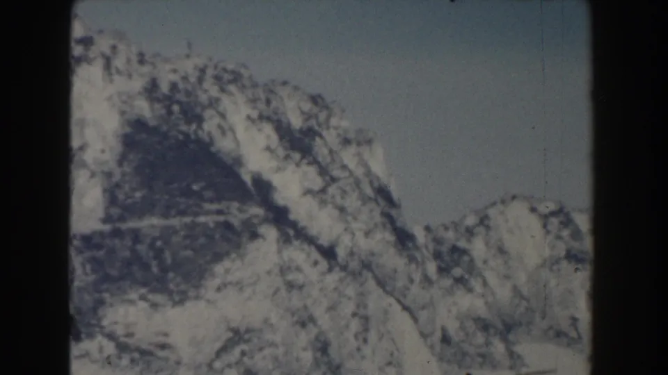 1959 Gibraltar-labeled 8mm frame with a steep snow-streaked peak and rugged dark rock surfaces.