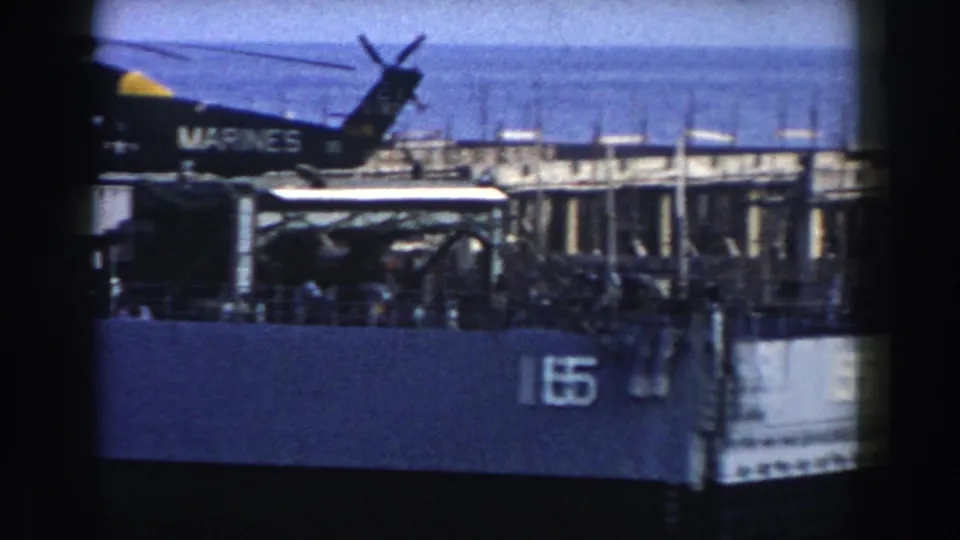 The final 1959 8mm frame shows the Marine Corps helicopter from the rear side on a naval deck, with hull number 15 below.