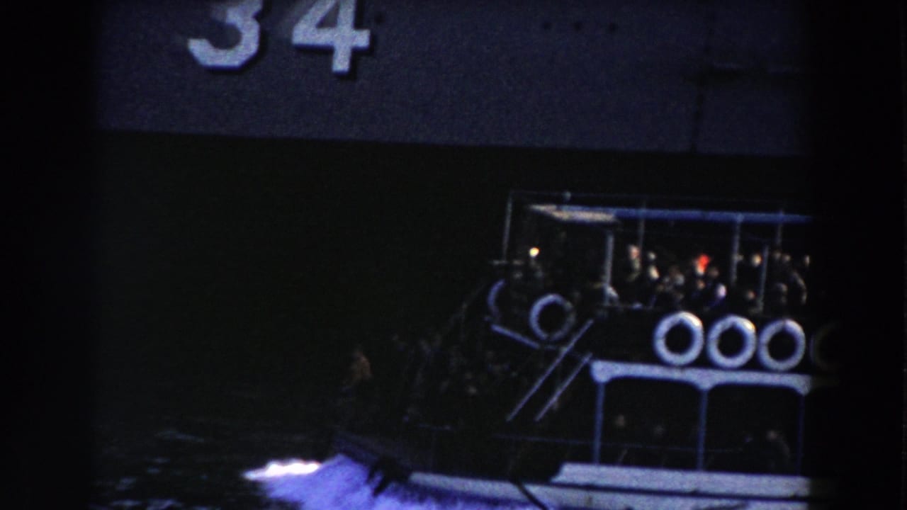 Crowded blue and white ferry beside a dark ship, with life rings along the rail.