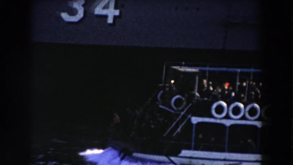 1959 Gibraltar footage shows a crowded blue and white ferry passing a dark ship at night, with life rings visible on the rail.