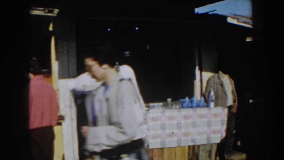 Casablanca 1959 frame with a passerby crossing the foreground while shoppers and a stall remain visible behind him.