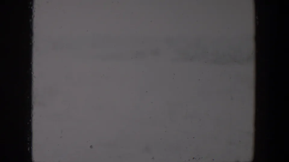 Soft, faded 8mm frame from the supplied 1957 Lubbock clip with little detail visible beyond an open outdoor setting.