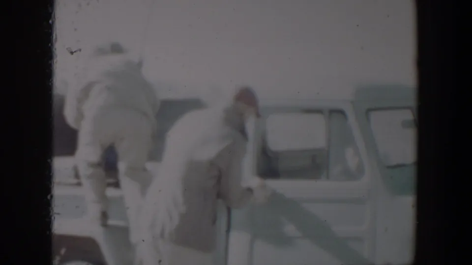 In supplied 1957 Lubbock, Texas footage, men in winter clothing move around a light-colored pickup with a rifle near the open cab area.