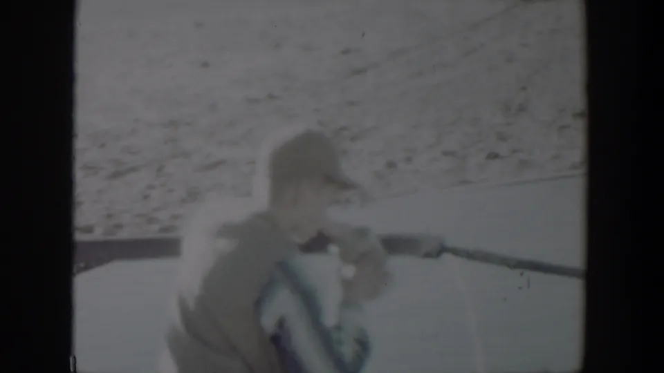 Young boy in a cap drinks from or holds a pipe in a sandy Lubbock outdoor scene.