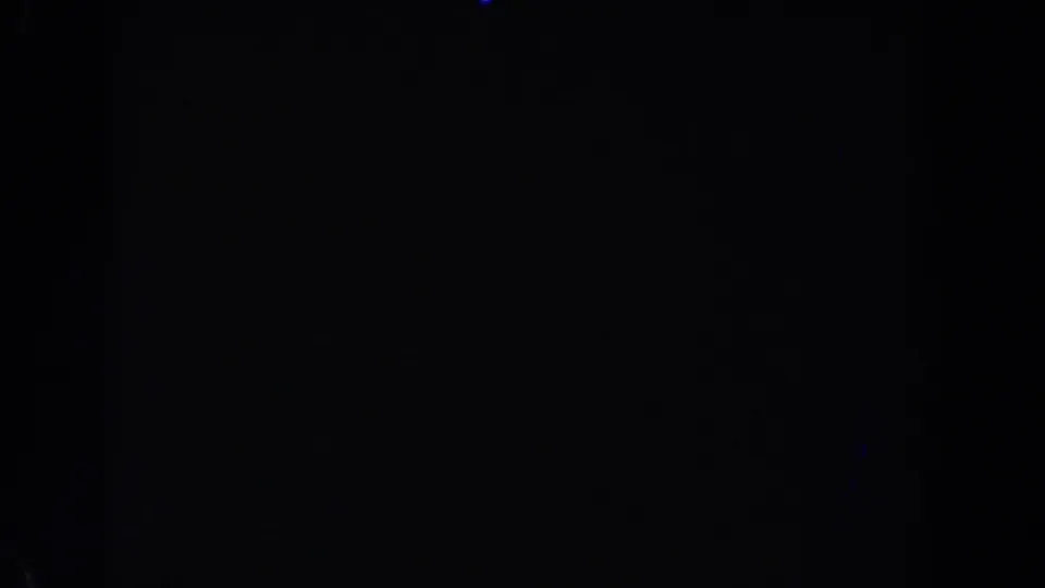 1962 Van Nuys 8mm night footage with faint blue light traces against an almost black moving-vehicle view.