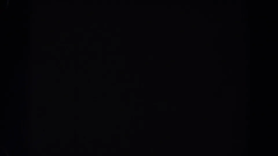 Near-total darkness in a 1962 Van Nuys 8mm frame, with only slight grain and indistinct specks visible.