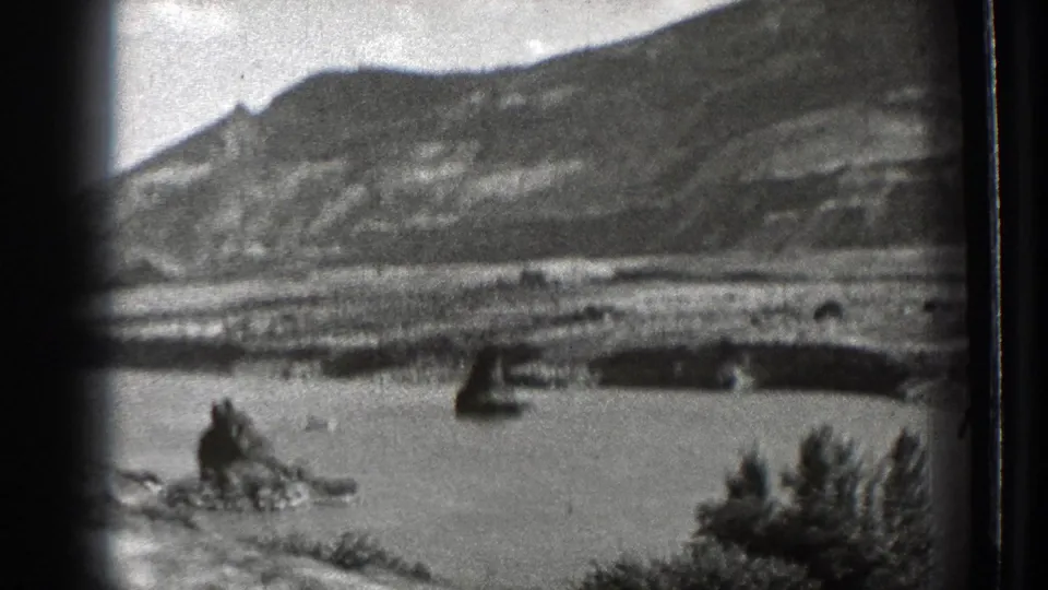 1939 8mm travel frame with a sloping mountain, open basin, sparse shrubs, and dark gate edges around the picture.