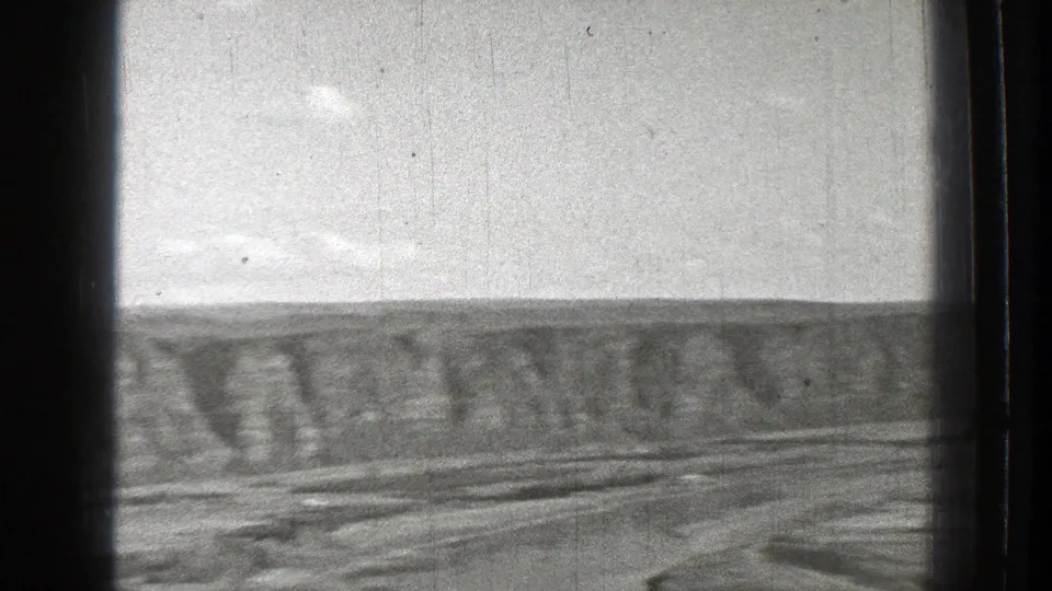 1939 Washington aerial frame showing a broad ridge, valley terrain, pale sky, and small-gauge film texture.