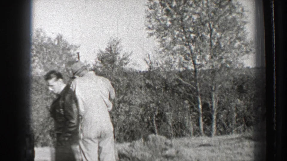 Two adult men in a Washington field appear to turn or reposition during the brief 1939 hunting scene.