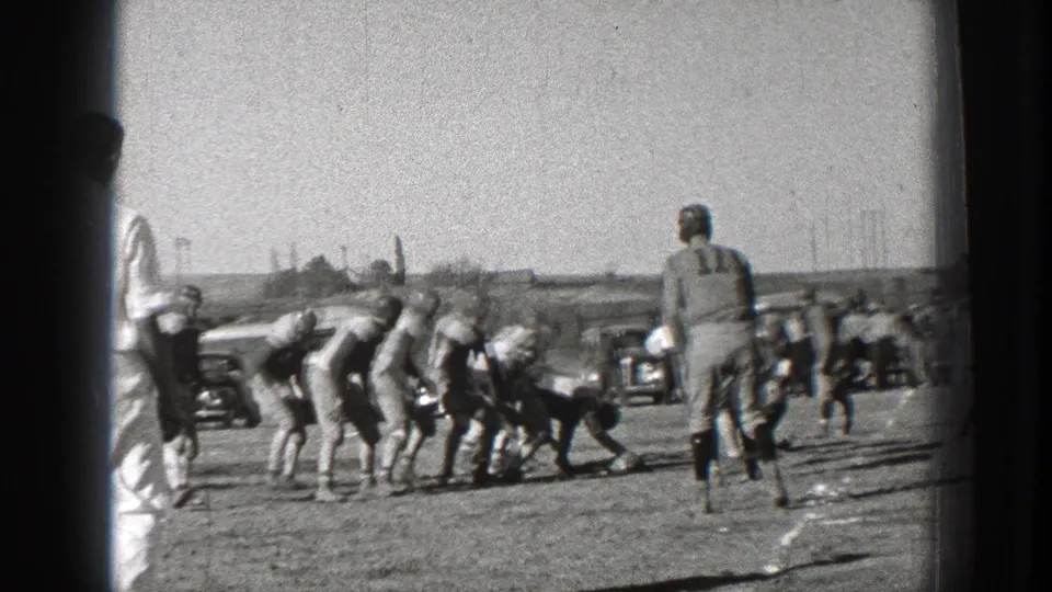 Washington 1939 football frame with players crouched around a loose-ball struggle and a numbered player watching from the right.