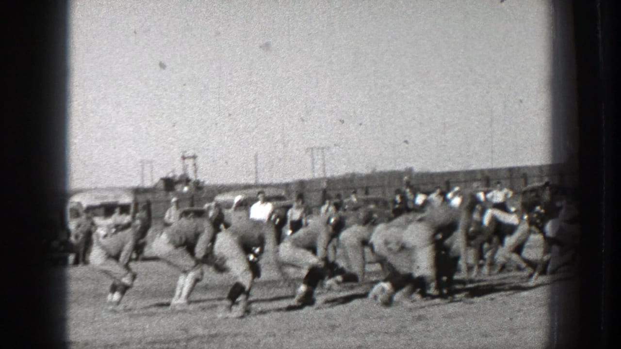 Football players begin moving from the line as the play starts.