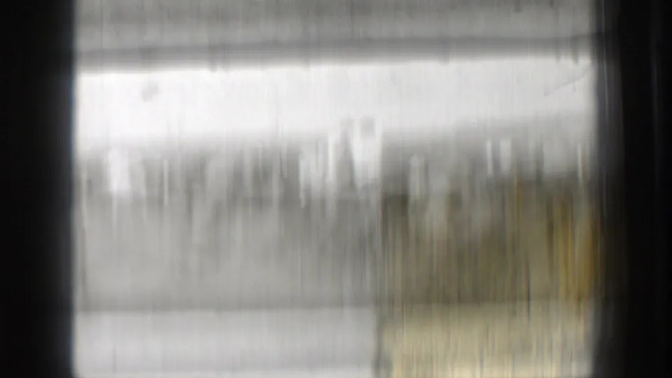 Motion-blurred 8mm frame from the Washington sports clip, with the field scene mostly obscured by camera or film movement.