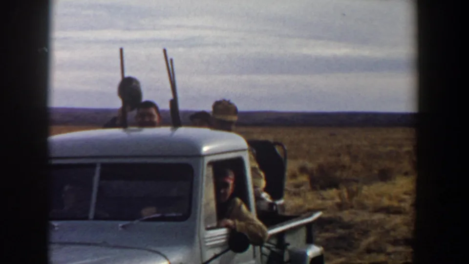 Near the end of the clip, men in hats are visible behind the pickup cab with rifles silhouetted against the Lubbock-area horizon.
