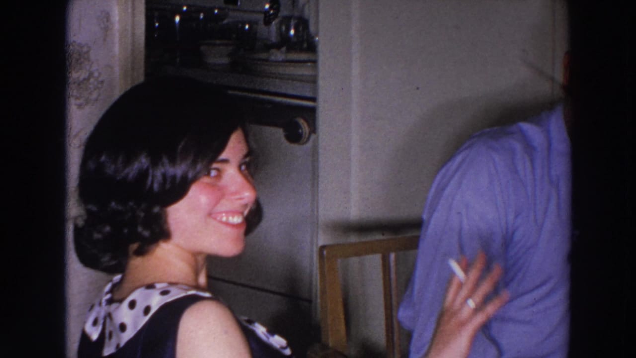 Smiling young woman holds a cigarette while facing a man in a blue shirt.