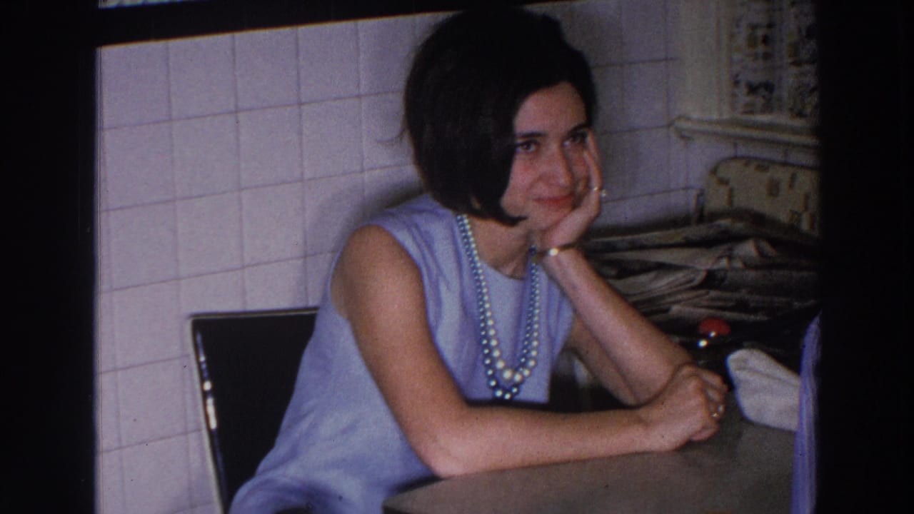 Young woman seated at a kitchen counter with her chin resting on her hand.