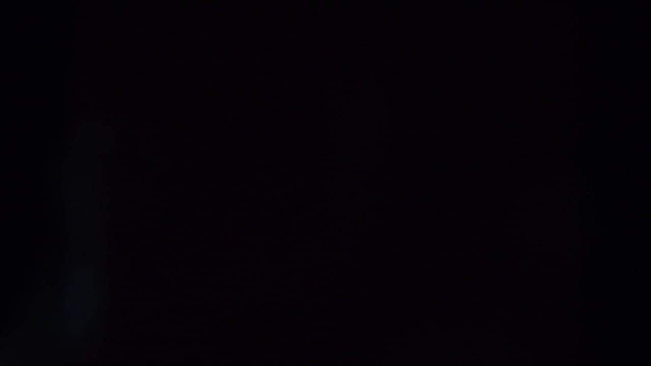 Mostly black frame with faint blue flare near the left edge.