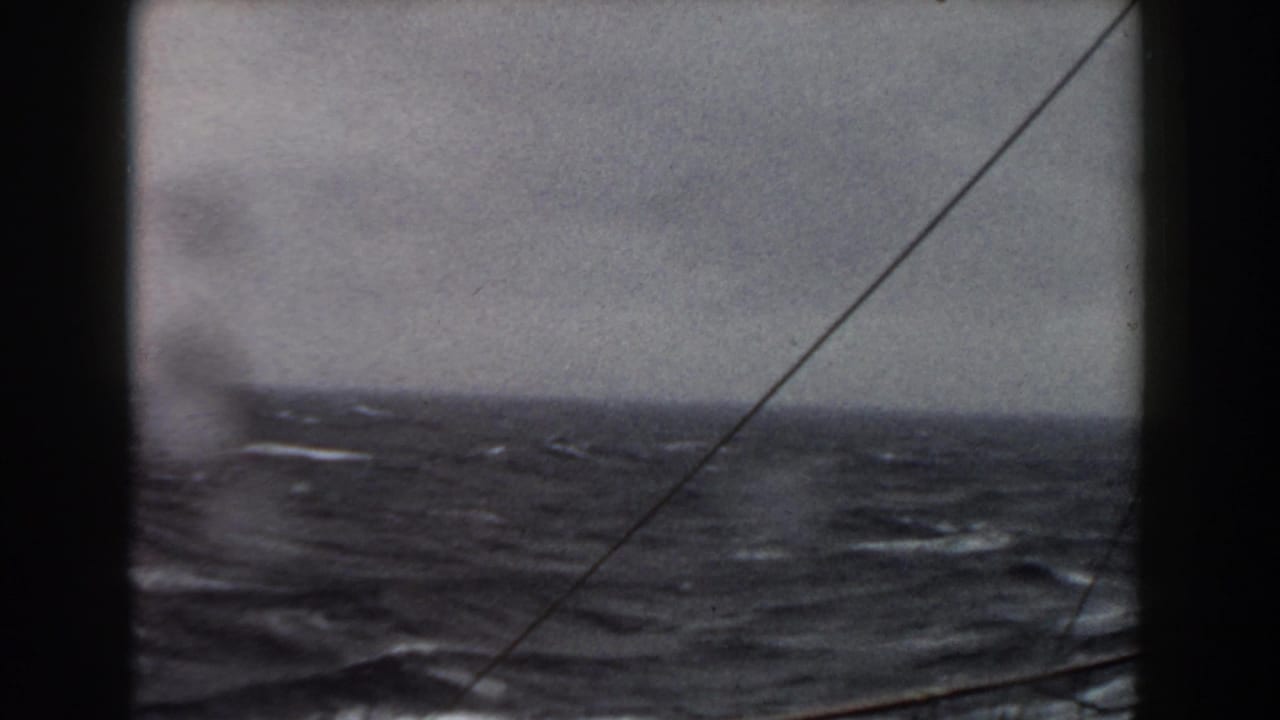 1959 8mm shipboard view of rough Atlantic water under an overcast sky, with rigging lines crossing the frame.