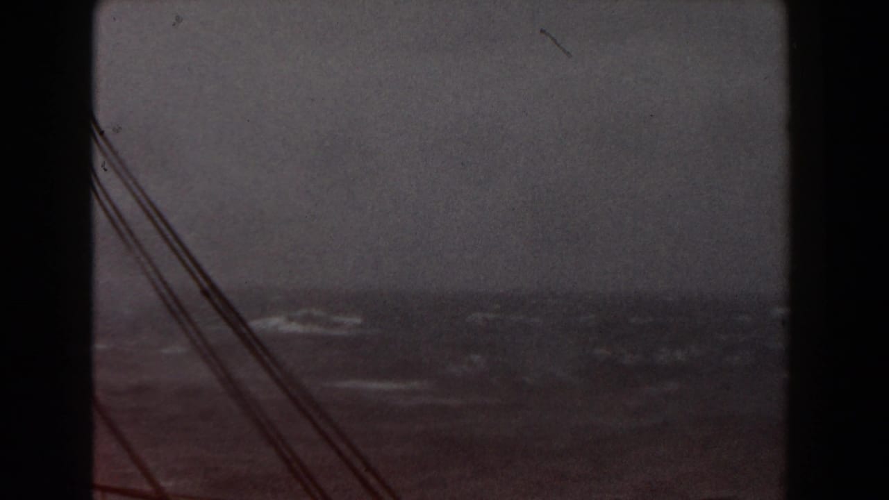 Dark ship structure and rigging frame rough waves under an overcast sky.