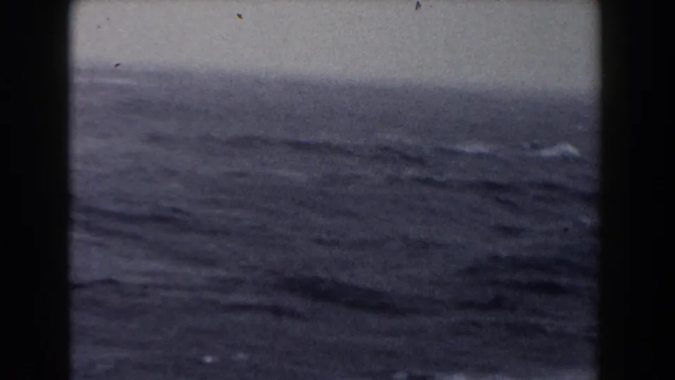1959 8mm view of rolling Atlantic waves, with a dark vertical border and muted overcast light.