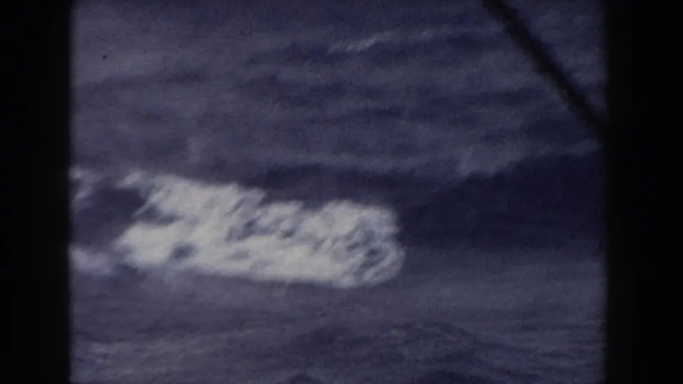 A soft 8mm view of a whitecap or breaking swell on dark blue Atlantic water, bordered by heavy dark frame edges.