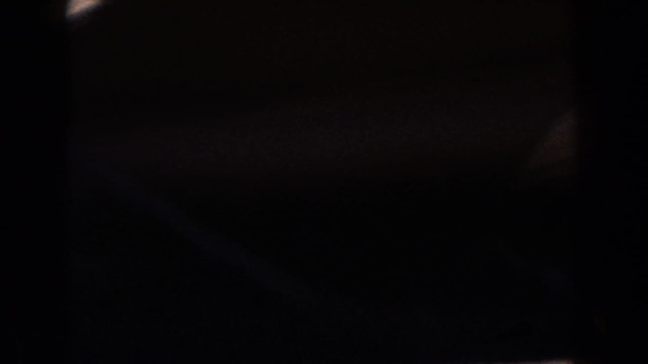 1960 Dearborn 8mm frame dominated by darkness, faint warm light, and blurred movement without an identifiable subject.