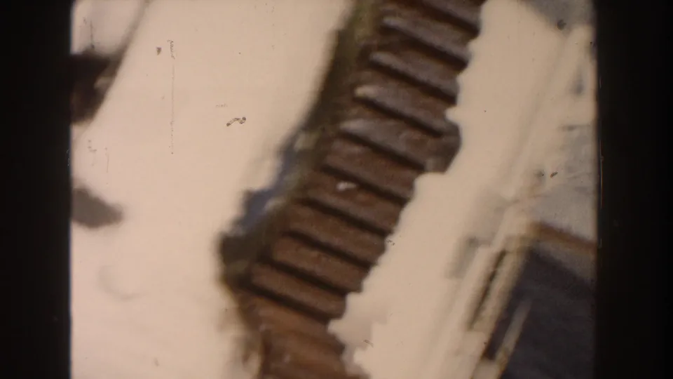 1960 Dearborn 8mm frame with a ribbed brown object crossing a bright background, seen in soft focus with dust marks.