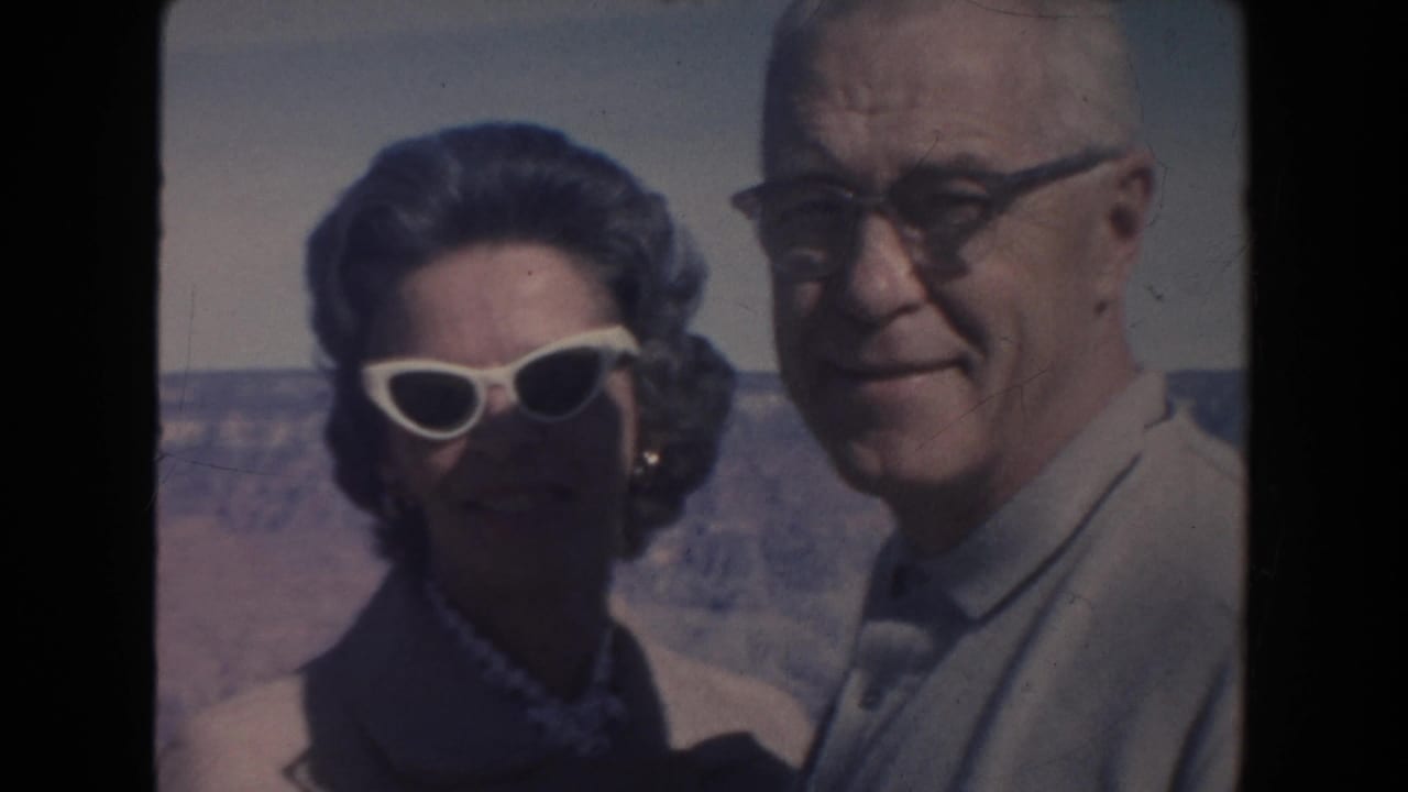 Older couple standing close together outdoors with a canyon landscape behind them.