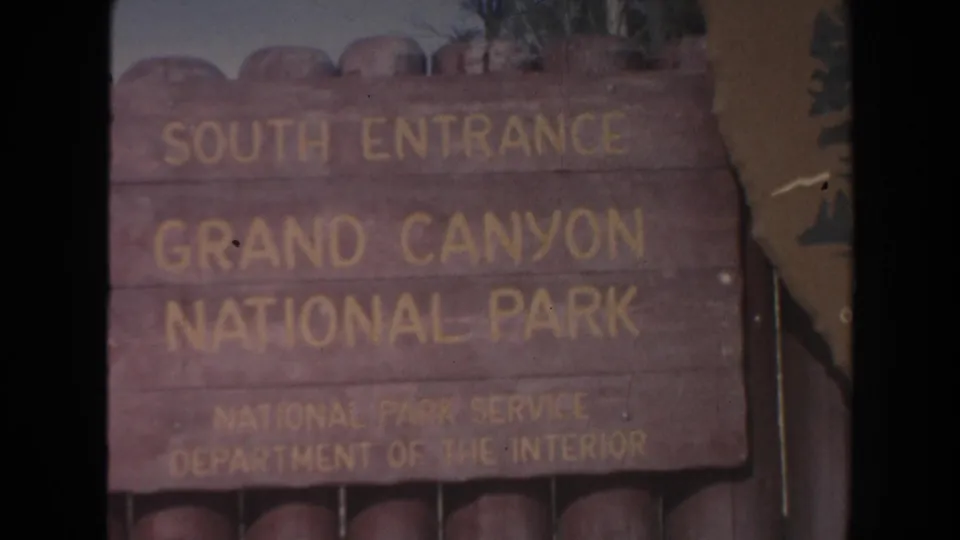 Close framed view of the South Entrance Grand Canyon National Park sign, with park service lettering and aged 8mm color.
