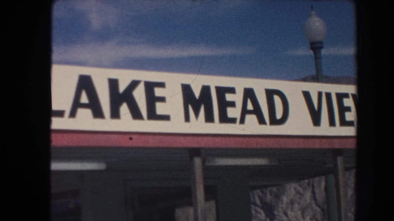 1962 Arizona 8mm frame showing part of a Lake Mead View sign, a street lamp, and blue sky from a visitor-shot angle.