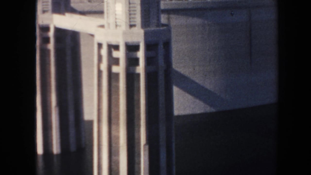 Close view of vertical dam tower forms and a shadowed concrete wall.