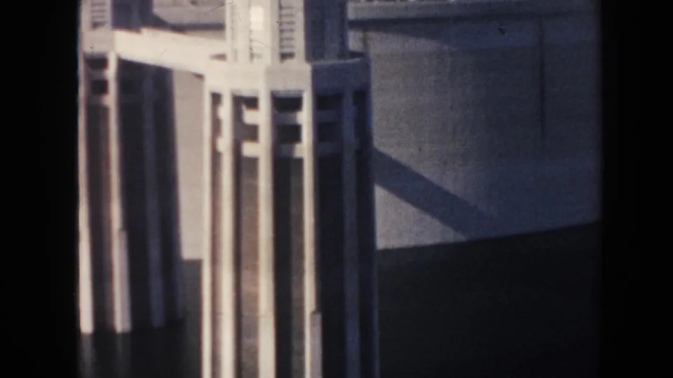 Close 1962 Hoover Dam detail showing vertical Art Deco tower forms against a broad concrete wall and hard shadow.