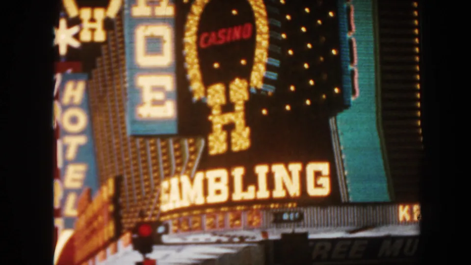 1962 8mm close view of illuminated hotel, casino, and gambling signage, softened by motion and night exposure.
