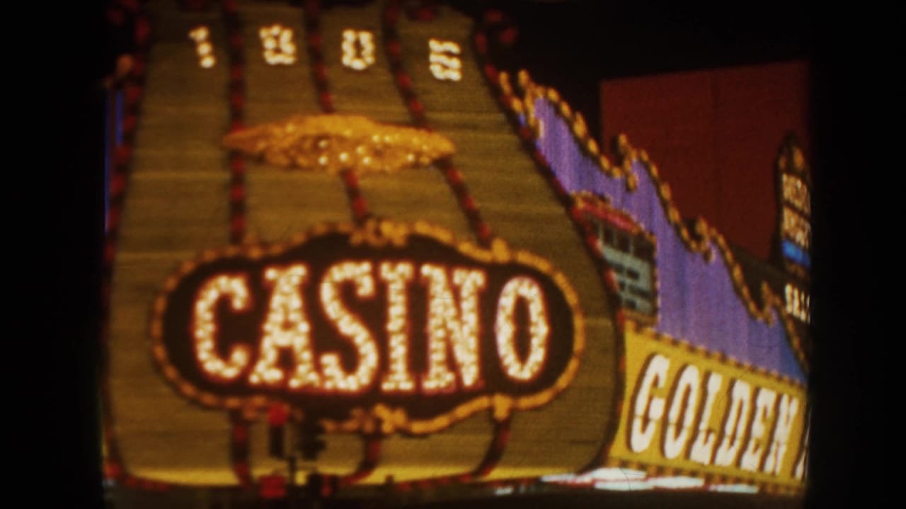 1962 8mm travel frame showing a night casino marquee with large CASINO lettering, bulb lights, and soft focus.