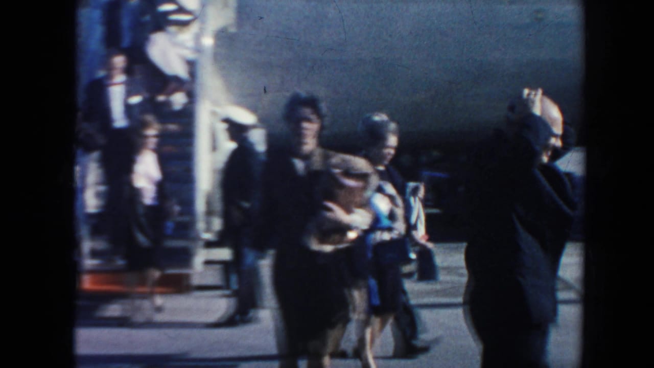 Passengers walk away from a blue-and-white Pan American plane beside portable stairs.