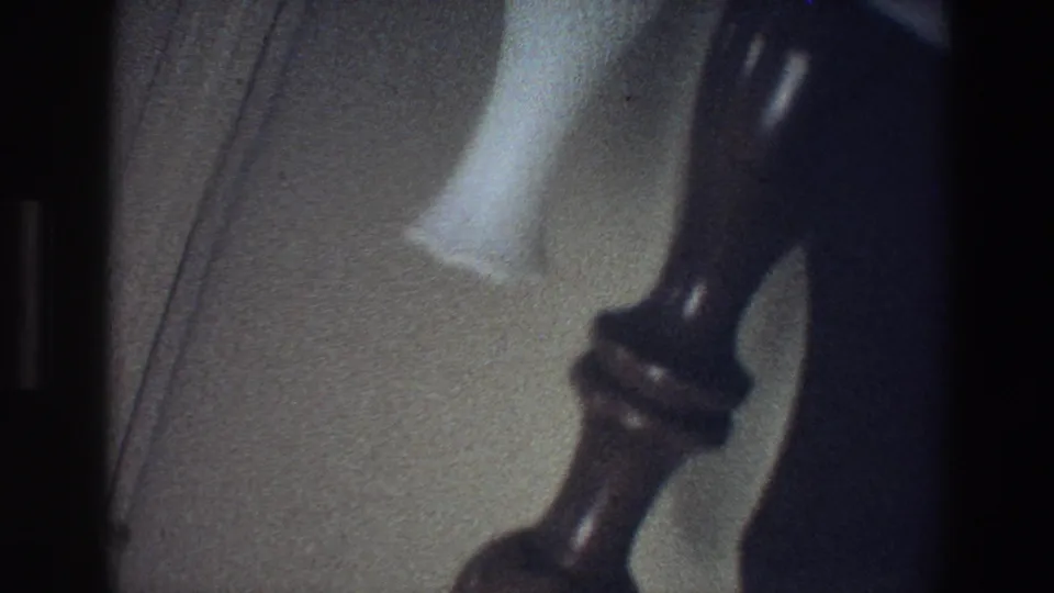 1973 Minnesota 8mm frame showing a dark handle-like interior fixture near a pale vertical surface.