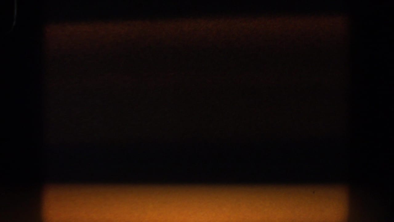 Dark blurred interior view with a warm band of light along the lower edge.