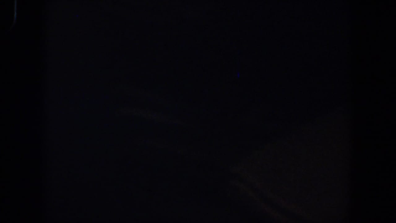 Very dark 1958 8mm home-movie frame from Lubbock metadata, with only faint grain and edge darkness visible.
