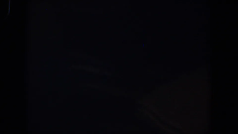 Very dark 1958 8mm home-movie frame from Lubbock metadata, with only faint grain and edge darkness visible.