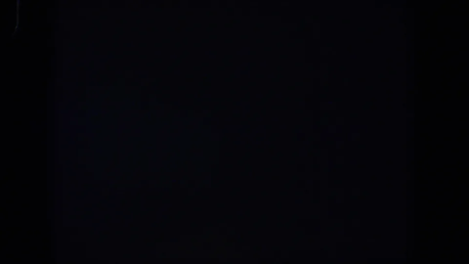 Nearly solid black 8mm frame from the 1958 Lubbock reel, with minor light specks and visible film grain.