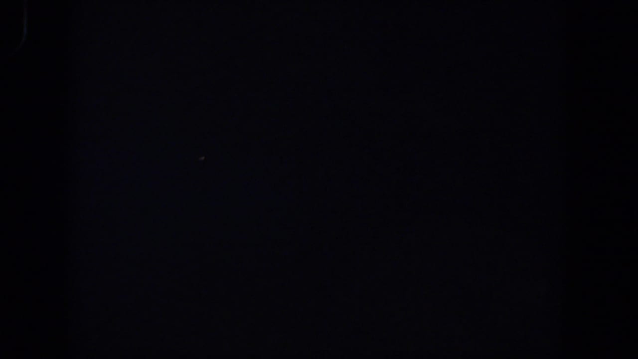 Near-black 1958 8mm home-movie frame from Lubbock with barely visible light traces and grain.