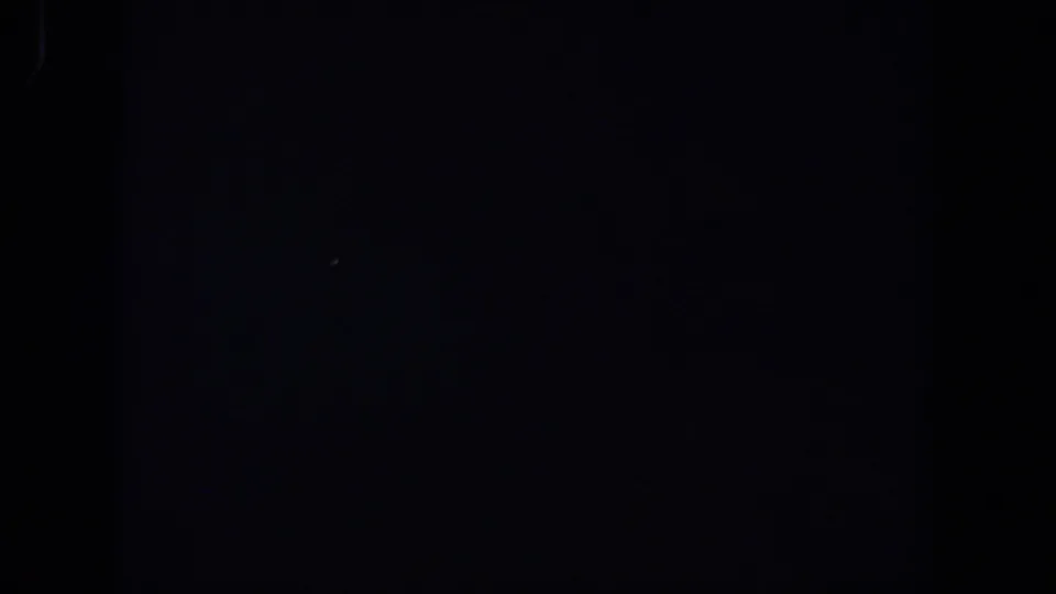 Near-black 1958 8mm home-movie frame from Lubbock with barely visible light traces and grain.