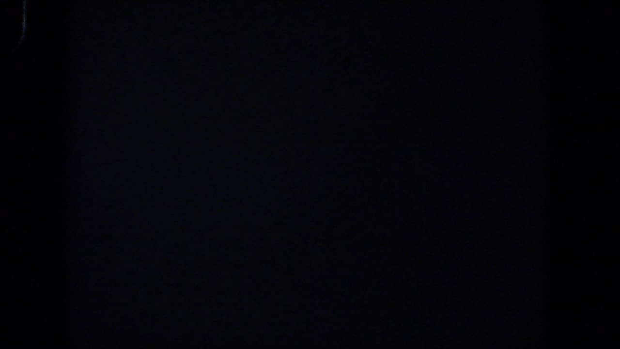 Underexposed 8mm frame from the 1958 Lubbock clip, showing darkness with subtle tonal variation.