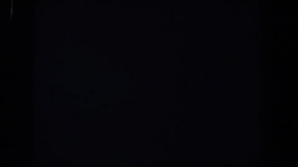 Underexposed 8mm frame from the 1958 Lubbock clip, showing darkness with subtle tonal variation.
