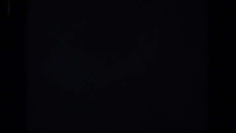 Nearly black 1958 Lubbock 8mm frame showing a faint vertical frame boundary and minimal visible detail.