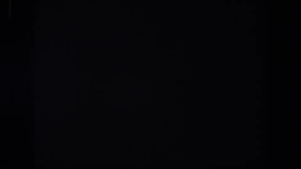 Underexposed 8mm frame from the Lubbock reel, showing faint traces in darkness and subtle film texture.