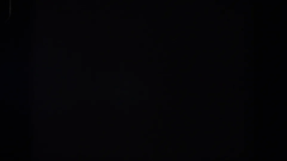 Dark 1958 Lubbock 8mm frame showing only faint grain, minor edge marks, and no identifiable scene.
