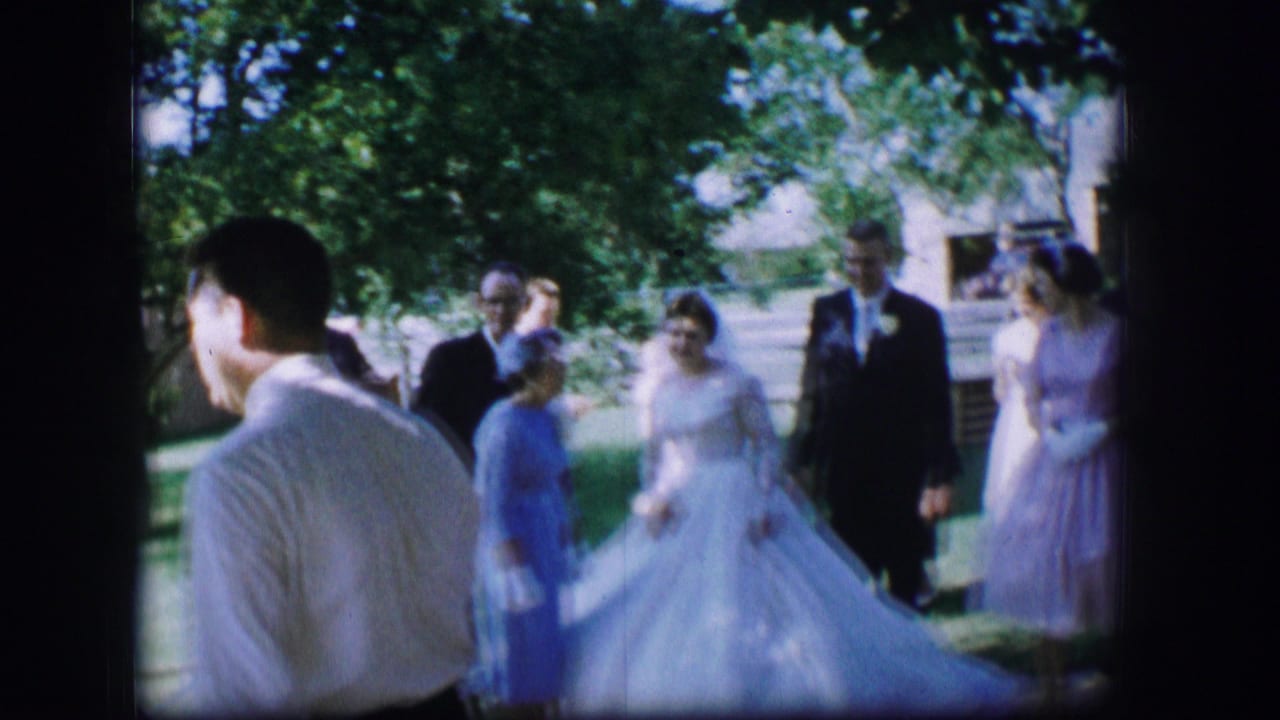 1962 Moberly, Missouri wedding guests gather outdoors as a bride in white and formally dressed attendees stand in dappled shade.