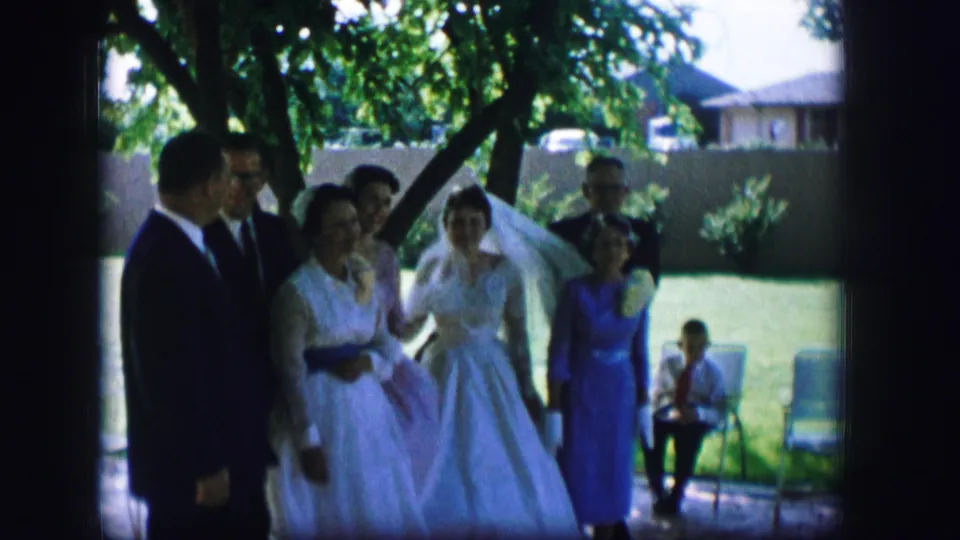 1962 Moberly wedding home movie showing the bride and guests moving through a shaded lawn area.