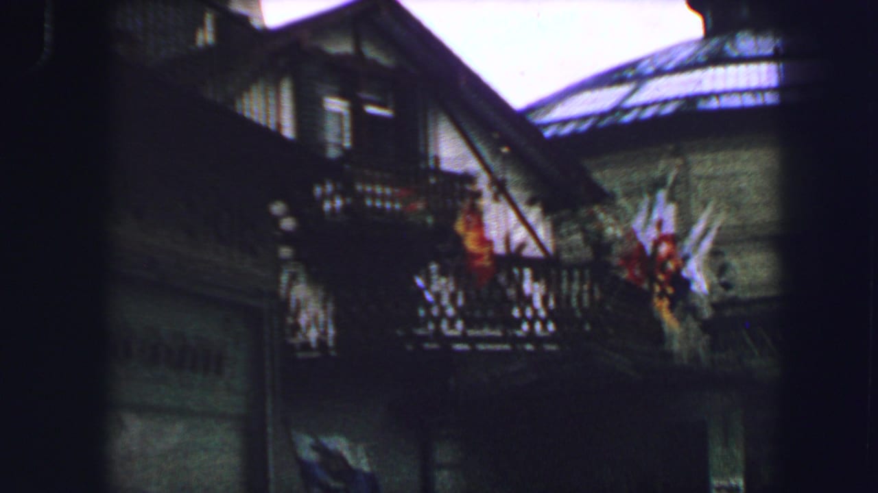 Upper floors of a traditional building with balconies and flags.
